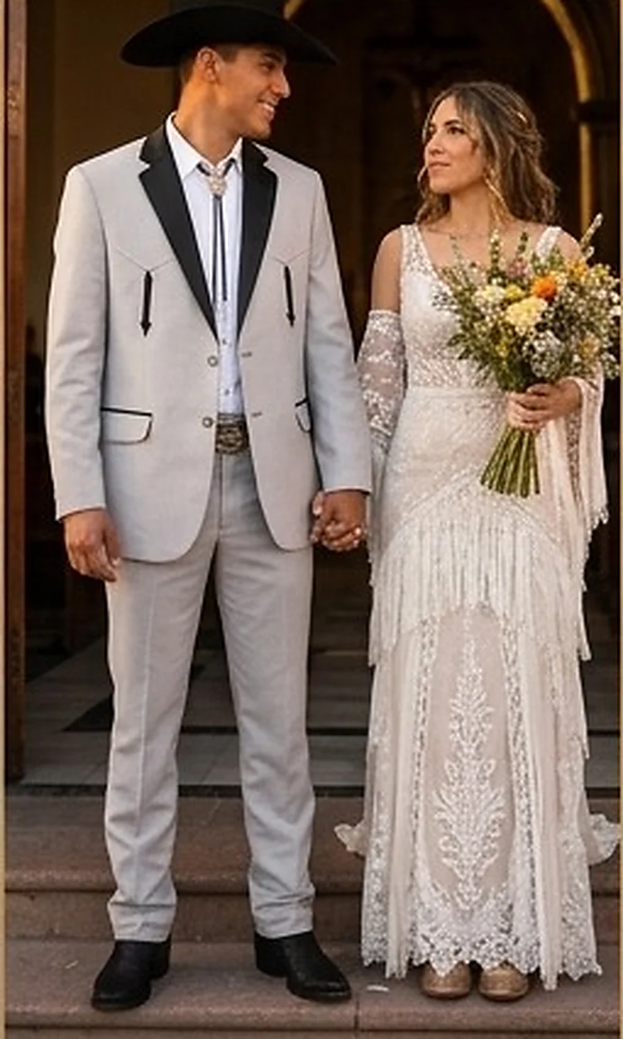 Traje vaquero gris claro con solapa negra, corbata de bolo, cinturón labrado y botines, de Filli's