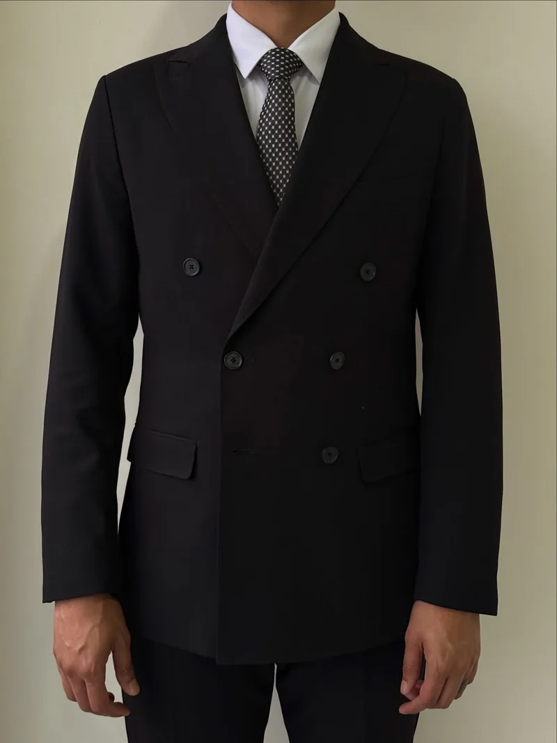 Traje negro cruzado con camisa blanca y corbata de puntos